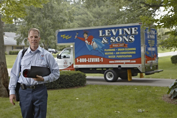 technician walking up to house with service truck in background